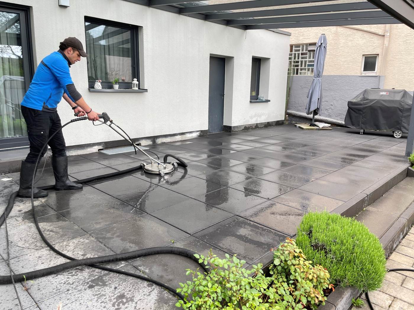 DA-DI Mitarbeiter reinigt eine Terrasse mit dem Flächenreiniger